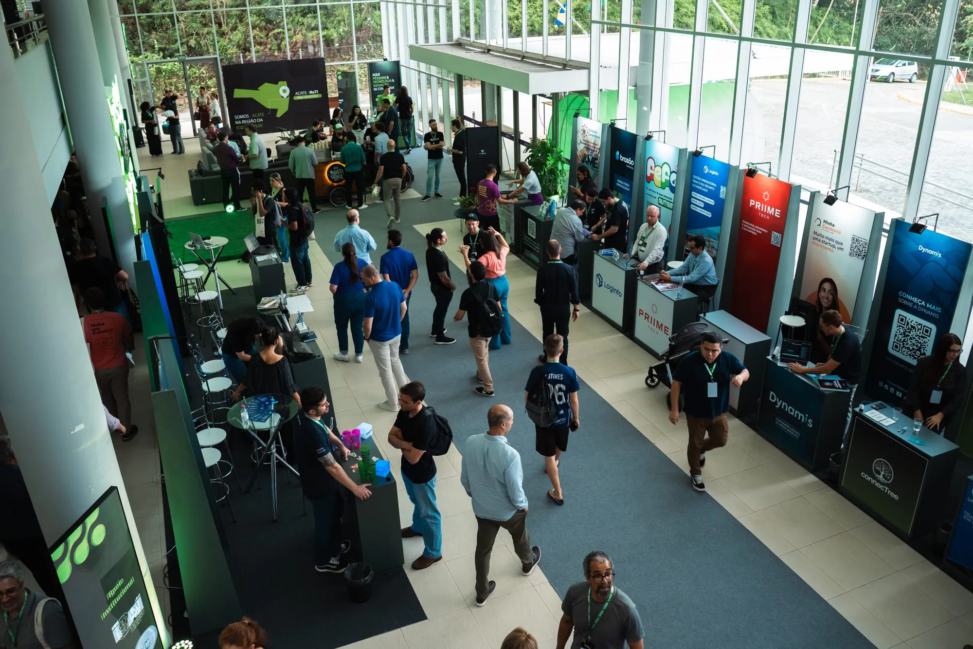 Vista do alto do espaço de expositores do Tech Summit 2025, com estandes de empresas e visitantes circulando.